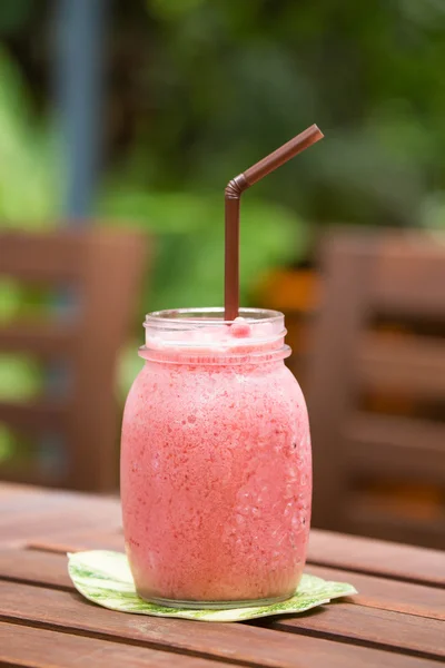 Een glas strawberry smoothie op een houten achtergrond Rechtenvrije Stockfoto's