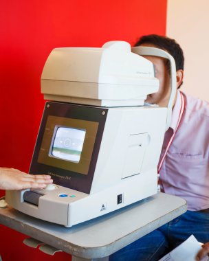 Young Optometrist measuring patient's eye pressure with tonomete clipart