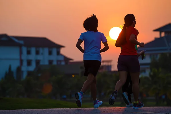 महिला दौड़ती, जॉगिंग, सूर्यास्त में दौड़ती . — स्टॉक फ़ोटो, इमेज