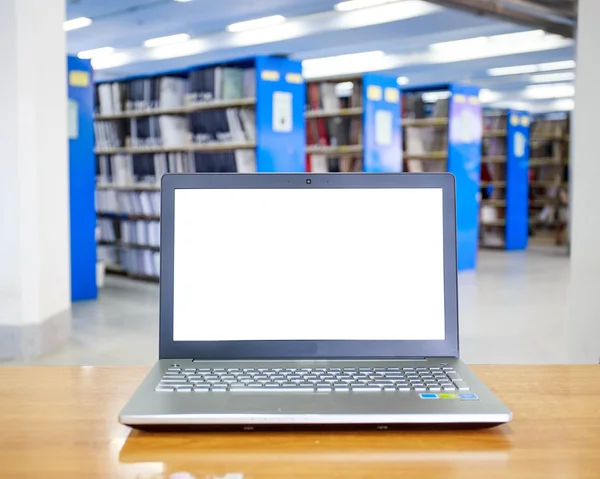 Laptop with blank screen on the table in library — Stock Photo, Image