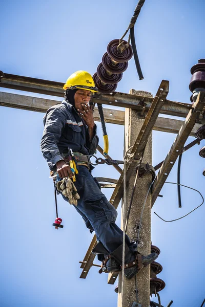 Elektriker raucht am Strommast — Stockfoto