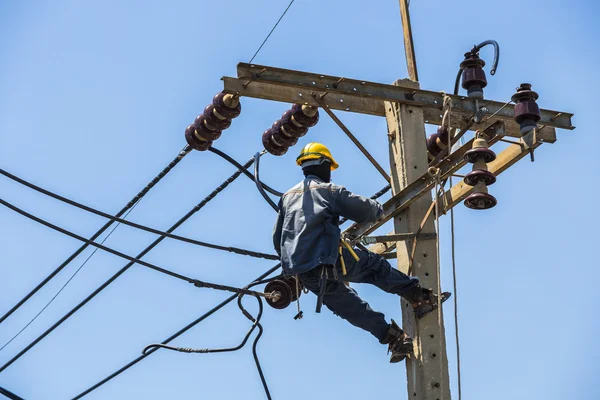 Elektrikçi elektrik direğine asılı