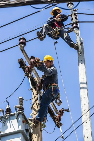 Elektrik direği üzerinde çalışan elektrikçiler
