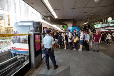 Security guard at BTS public train station watching passenger to ensure safety