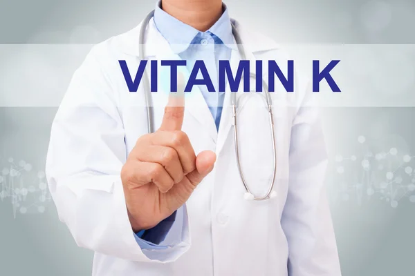 Médico com sinal de vitamina K — Fotografia de Stock