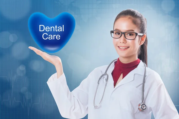 Female doctor holding heart with dental care sign on medical background. — Stock Photo, Image