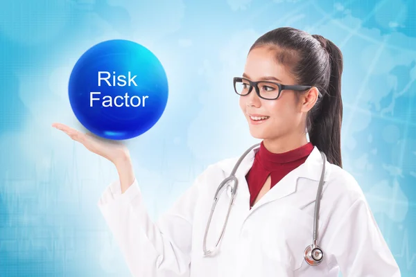Vrouwelijke arts bedrijf blauwe kristallen bol met risicofactor ondertekenen op medische achtergrond. — Stockfoto