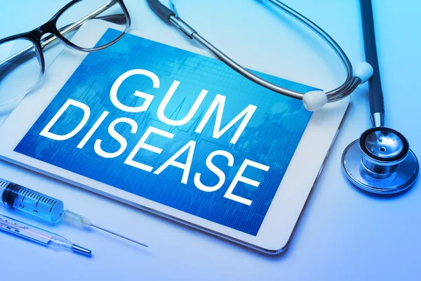 Gum disease word on tablet screen with medical equipment on background — Stock Photo, Image