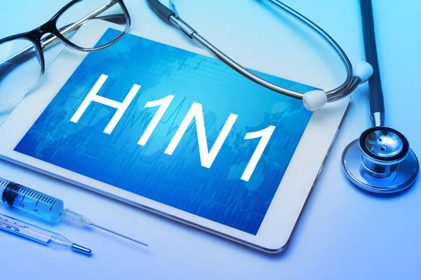 H1N1 ordet på Tablet PC-skärmen med medicinsk utrustning på bakgrund — Stockfoto