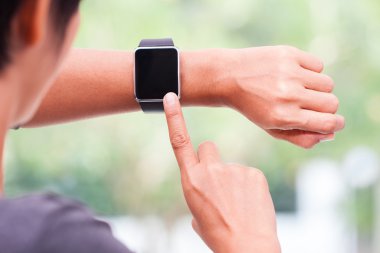 evde akıllı saatini kullanan genç kadın