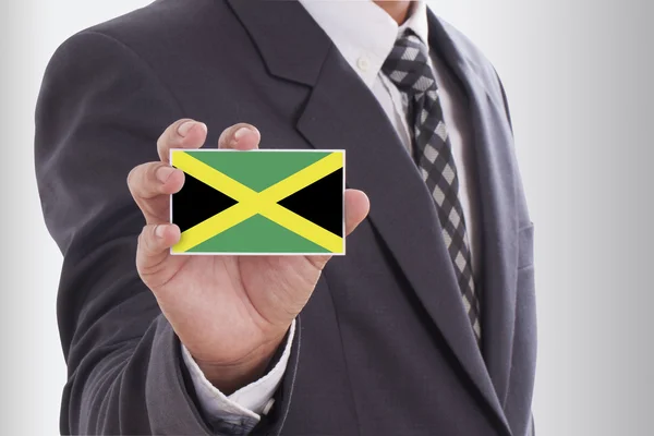 Biznesmen w garniturze gospodarstwa flaga Jamajki — Zdjęcie stockowe