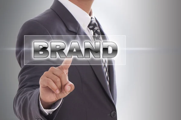 Affärsman hand röra varumärke word — Stockfoto