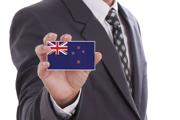Biznesmen w garniturze gospodarstwa flaga Nowej Zelandii — Zdjęcie stockowe