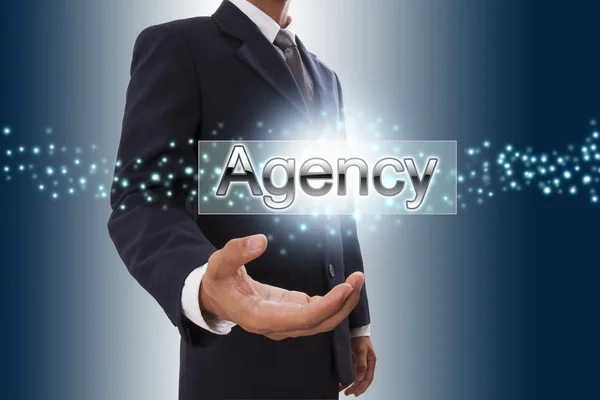 Рука бізнесмена, що показує кнопку агентства на віртуальному екрані . — стокове фото