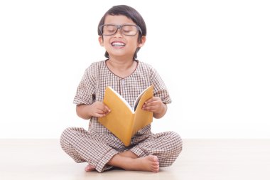 Sevimli çocuk gözlük takan bir kitap okuyor