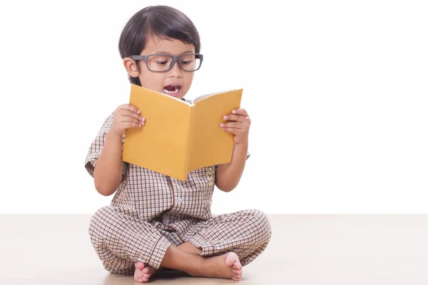 Lindo chico está leyendo un libro mientras usa gafas —  Fotos de Stock