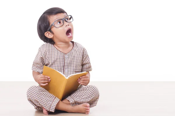 Schattige jongen is het lezen van een boek terwijl het dragen van een bril — Stockfoto