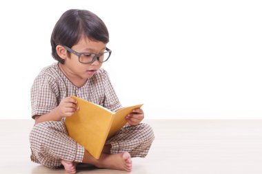 Sevimli çocuk gözlük takan bir kitap okuyor