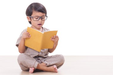 Sevimli çocuk gözlük takan bir kitap okuyor