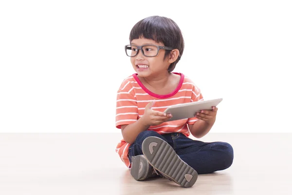Симпатичный мальчик играет в игру на планшете — стоковое фото