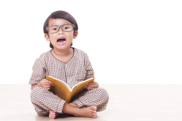 Rapaz bonito está lendo um livro enquanto usa óculos — Fotografia de Stock