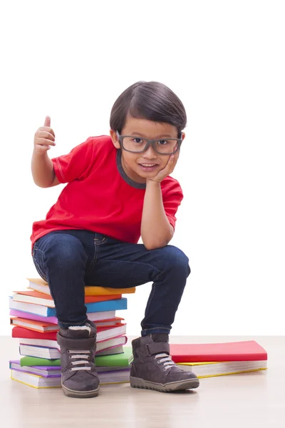 Jongen is lezen van een boek en duim omhoog teken weergegeven:. — Stockfoto