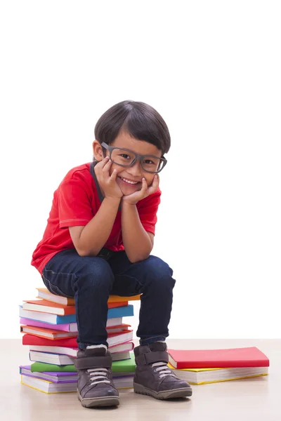 Glücklicher Junge sitzt und Bücher in der Hand hält — Stockfoto