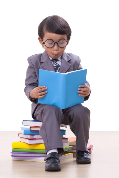 Bonito menino de terno lendo um livro — Fotografia de Stock