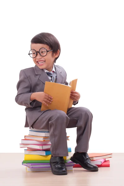 Bonito menino de terno lendo um livro — Fotografia de Stock