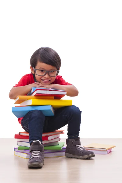 Netter Junge sitzt und hält Bücher — Stockfoto