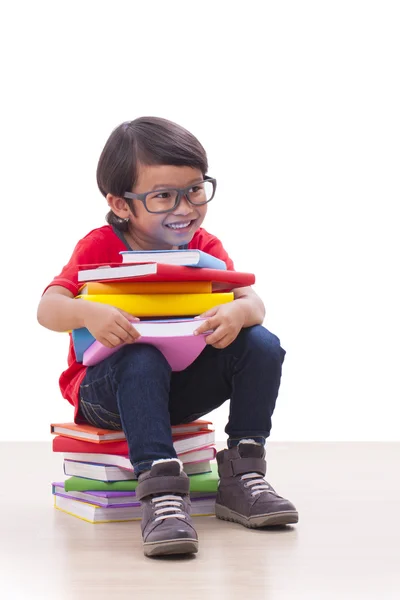 Garçon mignon assis et tenant des livres — Photo