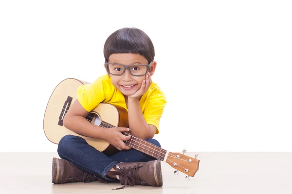 Маленький мальчик с гитарой укулеле — стоковое фото