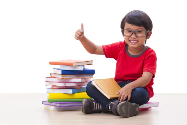 Roztomilý chlapec sedící na knihách — Stock fotografie