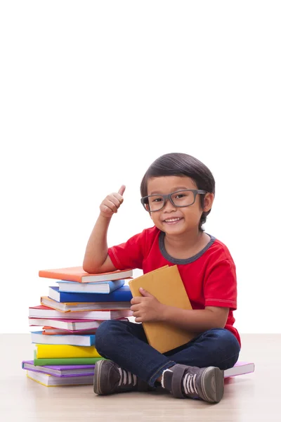 Netter Junge sitzt auf Büchern — Stockfoto