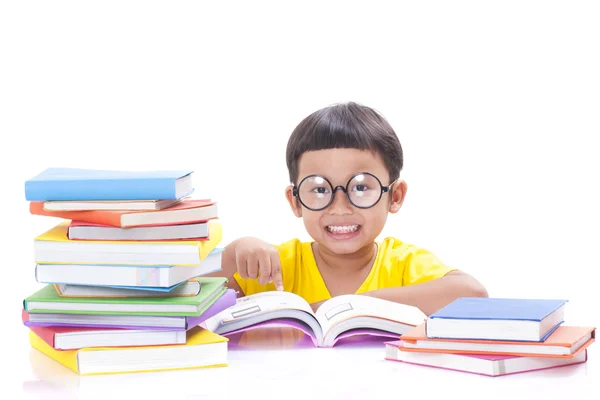 Menino bonito está lendo um livro enquanto usa óculos . — Fotografia de Stock