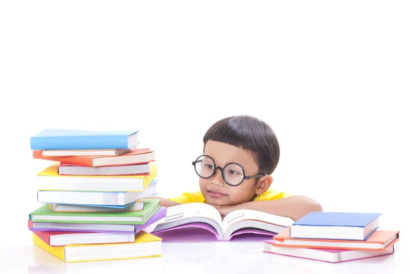 Netter kleiner Junge liest ein Buch, während er eine Brille trägt. — Stockfoto