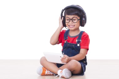Bir tablet için bağlı kulaklık ile mutlu çocuk