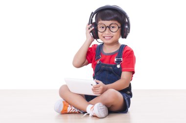Bir tablet için bağlı kulaklık ile mutlu çocuk