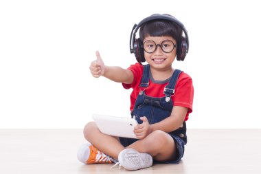 Bir tablet için bağlı kulaklık ile mutlu çocuk