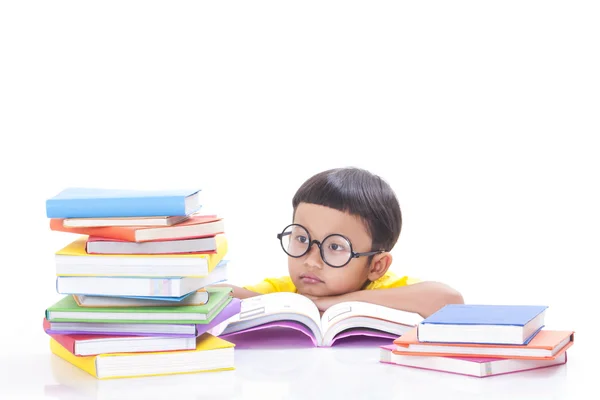 Netter kleiner Junge liest ein Buch, während er eine Brille trägt. — Stockfoto