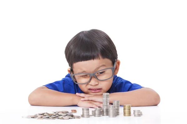 Netter Junge mit einem Stapel Münzen — Stockfoto