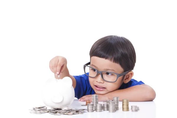 Lindo chico con una pila de monedas y mostrando el pulgar hacia arriba signo . — Foto de Stock