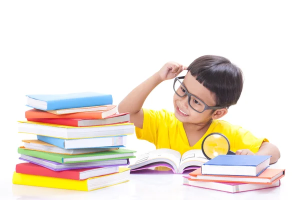 Netter kleiner Junge liest ein Buch, während er eine Brille trägt. — Stockfoto
