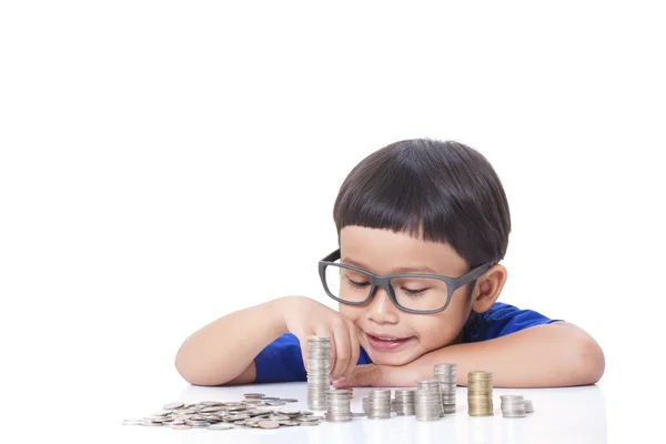 Netter Junge mit einem Stapel Münzen — Stockfoto