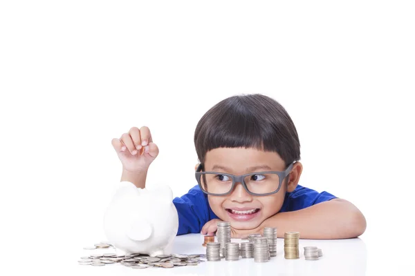 Roztomilý chlapec šetří peníze v bance prasátko — Stock fotografie