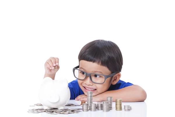 Cute boy saving money in piggy bank — Stock Photo, Image