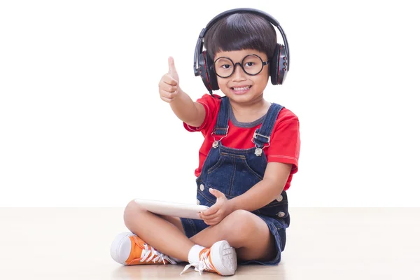 Gelukkige jongen met hoofdtelefoon aangesloten op een Tablet PC — Stockfoto