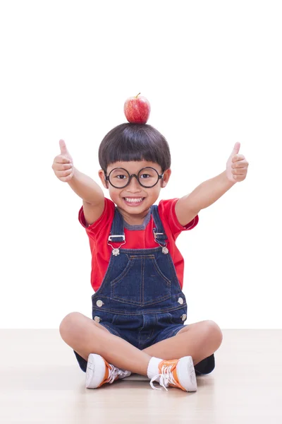 Liten pojke med rött äpple och visar tummen upp — Stockfoto