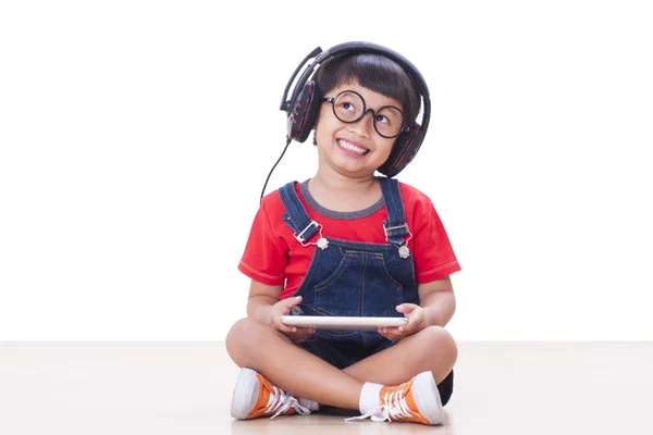 Ευτυχισμένο αγόρι με τα ακουστικά συνδεδεμένα με μια ταμπλέτα — Φωτογραφία Αρχείου