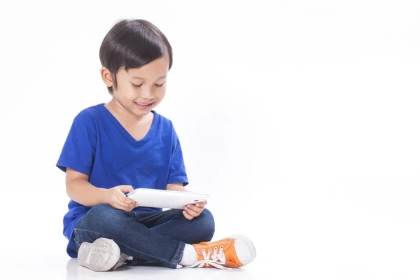 Söt pojke spelar ett spel på dator tablet — Stockfoto